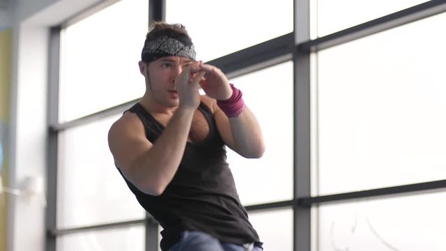 Young strong man workout swing arms and legs doing martial arts in gym