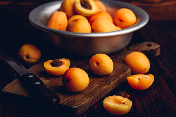 Mellow apricots with knife over cutting board