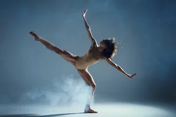 Abwaschbare Fototapete Dancing in cloud concept. Muscle brunette beauty female girl adult woman dancer athlete in fog smoke fume wearing dance bodysuit making stretches dance element performance on isolated grey background © Monstar Studio