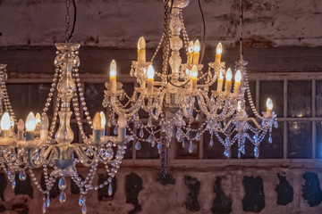 Vintage chandeliers on the background of old walls and Windows. The old interior of the room.