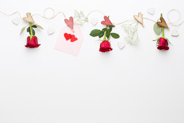 Flowers composition. Frame made of red rose on white background. Flat lay, top view, copy space.