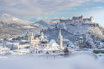 Fototapeta premium Panorama Salzburga zimą: zaśnieżone historyczne centrum, słońce