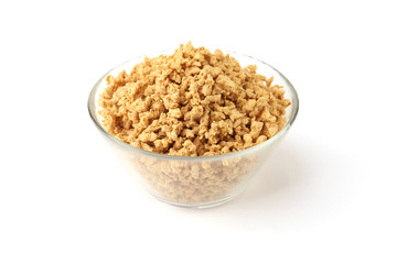 Raw soy mince in glass bowl isolated on white background. Dry soya mince meat.