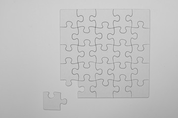 white, empty puzzles with a missing piece on a white background
