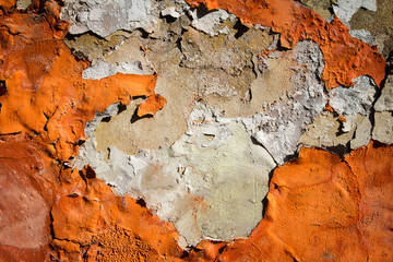 Orange plaster peeling off an old wall