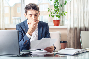 Naklejka premium Male lawyer sitting at a work place examing documents. Concept of the office working with documents