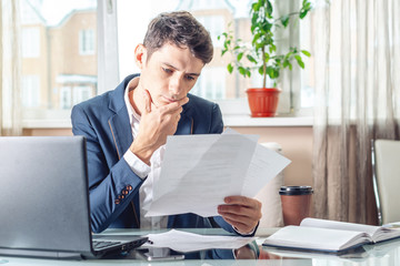 Male lawyer sitting at a work place examing documents. Concept of the office working with documents