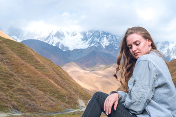 Beautiful girl on a mountain background of Svaneti, mountain Shkhara, relax while traveling.