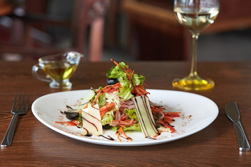 a wonderful cheese salad with carrots, onions and lettuce served on a table with olive oil and white wine
