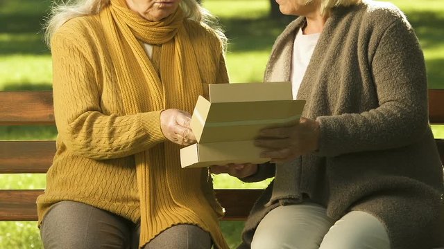 Unhappy old women watching photo together, remembering relatives, bereavement