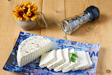 Fototapeta na wymiar White cheese on a blue plate on a wooden background