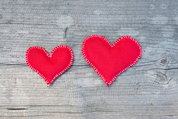 Red fabric hearts over wooden background, top view
