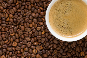 white cup of coffee on beans closeup