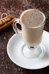 Sahlep drink and cinnamon sticks on wooden background
