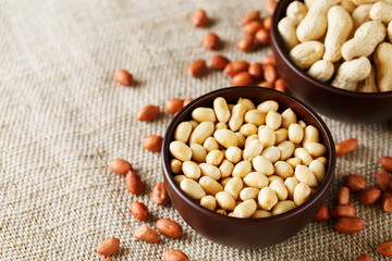 Peanuts in the shell and peeled closeup in a cup