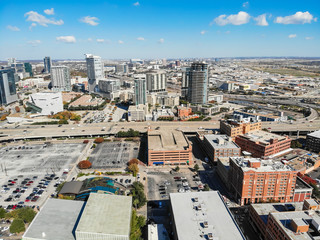 Aerial drone view uptown Dallas, Texas during sunny autumn day. Dense of modern skylines office building along Texas State Highway Spur 366 (Woodall Rodgers Freeway), colorful fall leaves