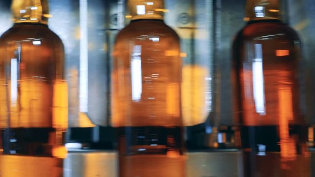 Close up of moving glass bottles filled with beer