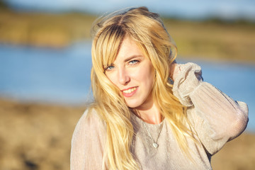 Outdoor close up portrait beautiful blonde girl with youth and skin care attractive looking at camera. Light key