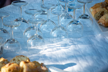 Table served outside in garden with many empty wine glasses for party, celebration or wine tasting