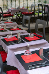 Empty cosy french street cafe or brasserie located on small river with served tables ready for visitors