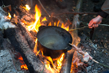 Roast sausages over a fire in nature.