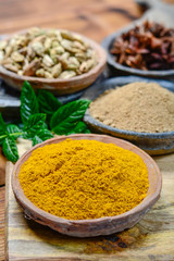 Old clay bowls wirh curry powder seeds close up, spices collection