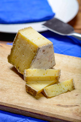 Piece of French Tomme cheese, produced in French Alps and in Switzerland close up