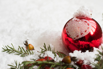 Merry Christmas - Christmas balls on the snow, winter bokeh background, red balls on the snow, rays of light