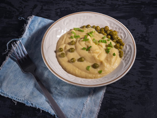 Plate with mashed potatoes and green peas on blue deen napkin
