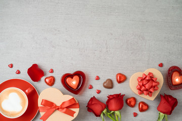 Valentine's day background with coffee cup, heart shape chocolate, candles, rose flowers and gift...