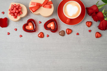 Valentine's day background with coffee cup, heart shape chocolate, candles and gift boxes.