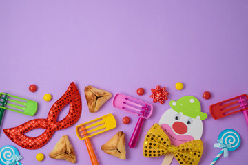 Jewish holiday Purim background with cute paper clowns character, hamantaschen cookies and carnival mask.