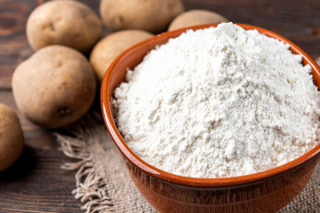 Potato starch on dark wooden background.