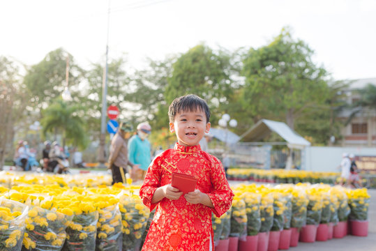 Portrait of a Asian boy on traditional festival costume. Cute little Vietnamese boy in ao dai dress smiling. Tet holiday. Lunar New Year Vietnam