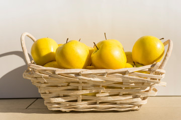 White basket of yellow apples