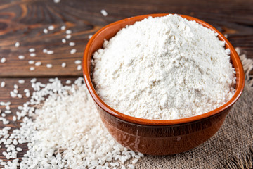 Fototapeta na wymiar Rice flour on wooden background.