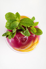 glass of lemonade with mint and fruits isolated on a white background