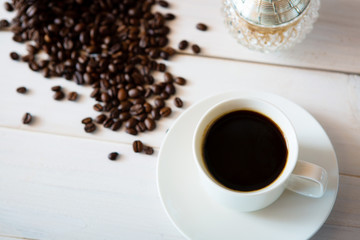 Obraz premium cup of coffee and beans on white wooden background