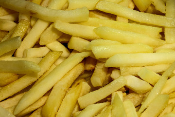 French fries frying in oil in a deep fat fryer