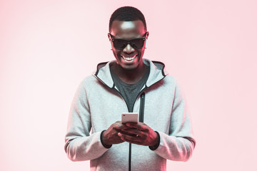 Excited african american guy using mobile phone
