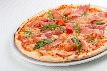 Pizza with prosciutto and arugula. On white background