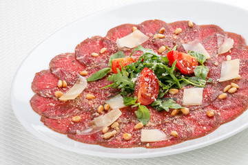Tuna carpaccio with Parmesan cheese.  On white background