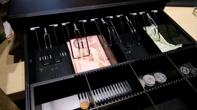cashier open the cash register drawer machine to give change to customer