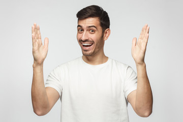 Young man showing big size gesture with hands, emphasizing great amount of something