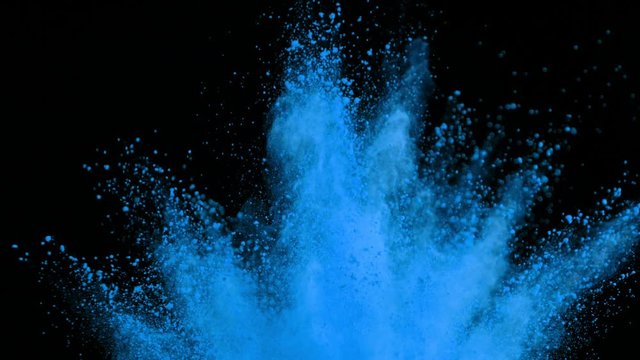 Super slowmotion shot of color powder explosions isolated on black background.