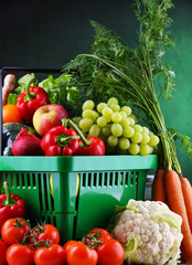 Fresh organic fruits and vegetables in plastic shopping basket