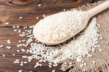 Rice on dark wooden background.