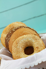 Freshly baked bagels in bread basket on blue background with copy space
