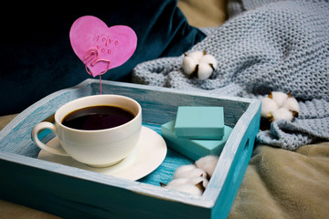 Romantic morning on Valentine's Day - breakfast in bed on a wooden turquoise tray a cup of coffee, gift boxes