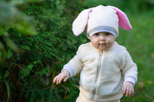 Kid in rabbit costume walking in park.